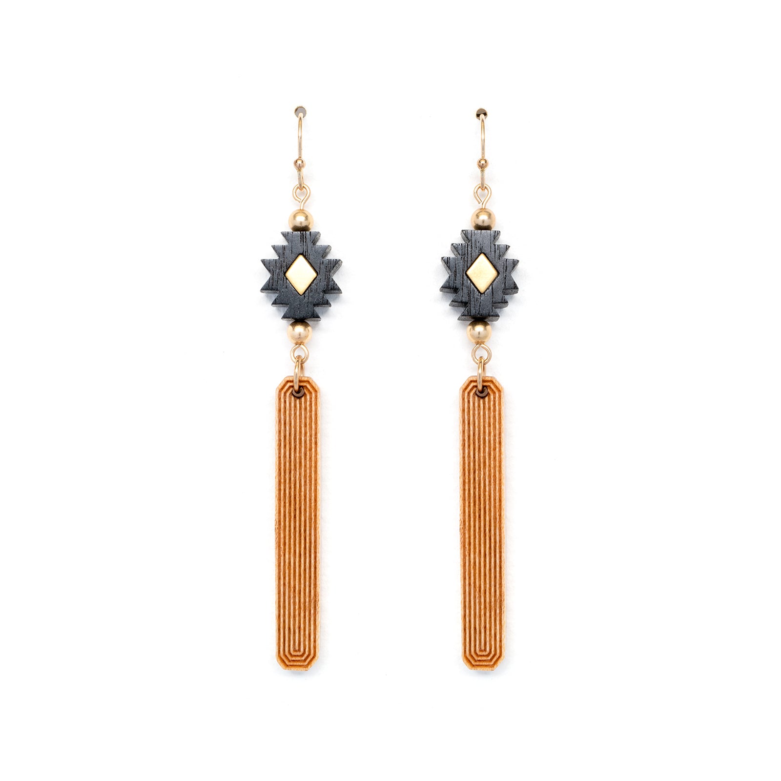 Black, gold and natural wood colored earrings made from laser carved wood laying flat on white backgound.