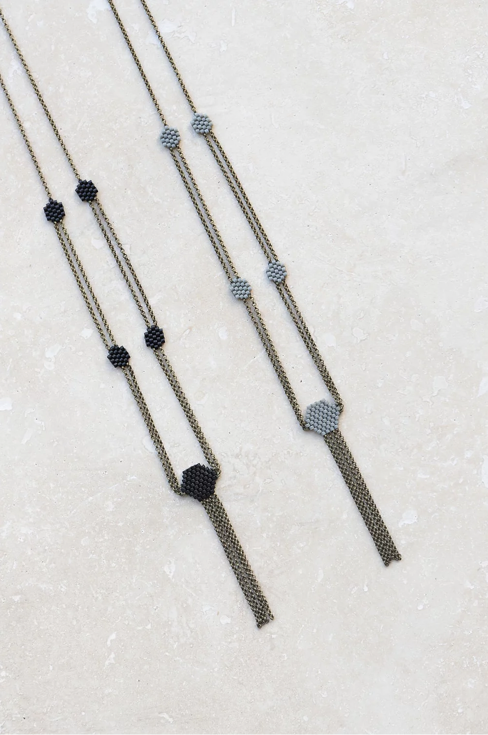 Delicate beaded chain necklaces in black and gray.