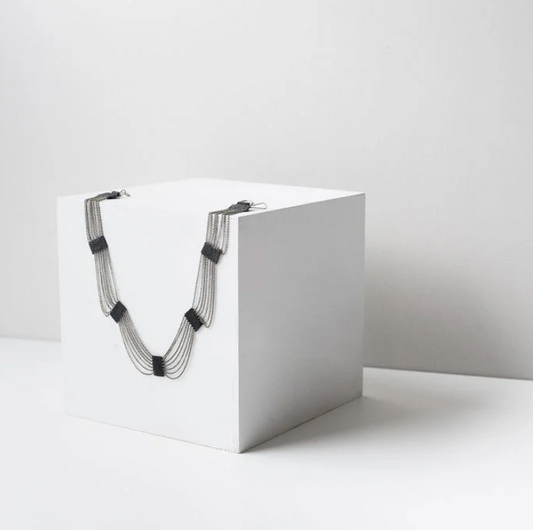Elegant draping necklace made of chain and black beads.