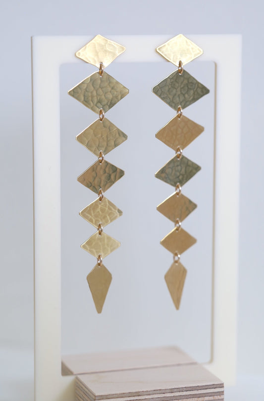 Long gold earrings made from diamond shapes that hang straight down.