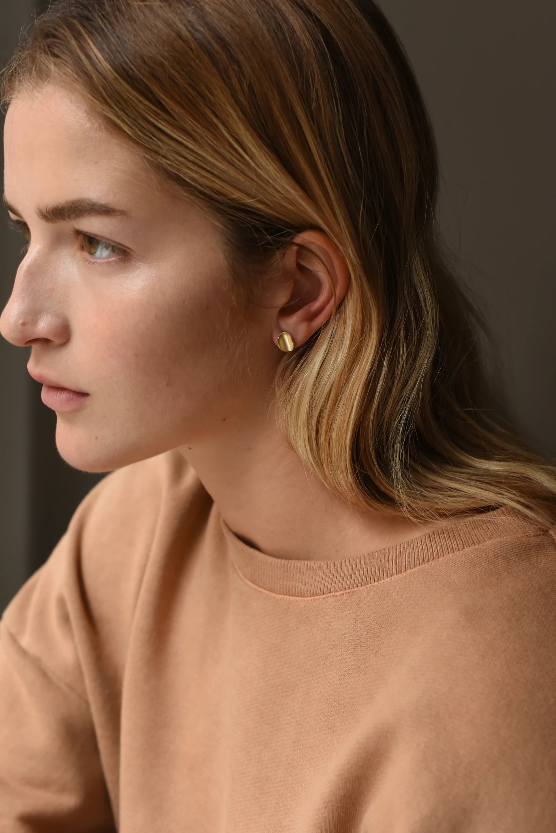 Curved organic shaped gold earring studs.