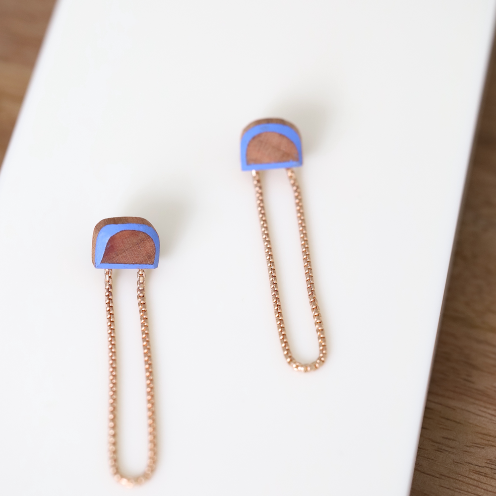 Stud earrings made from blue painted wood and brass chains.