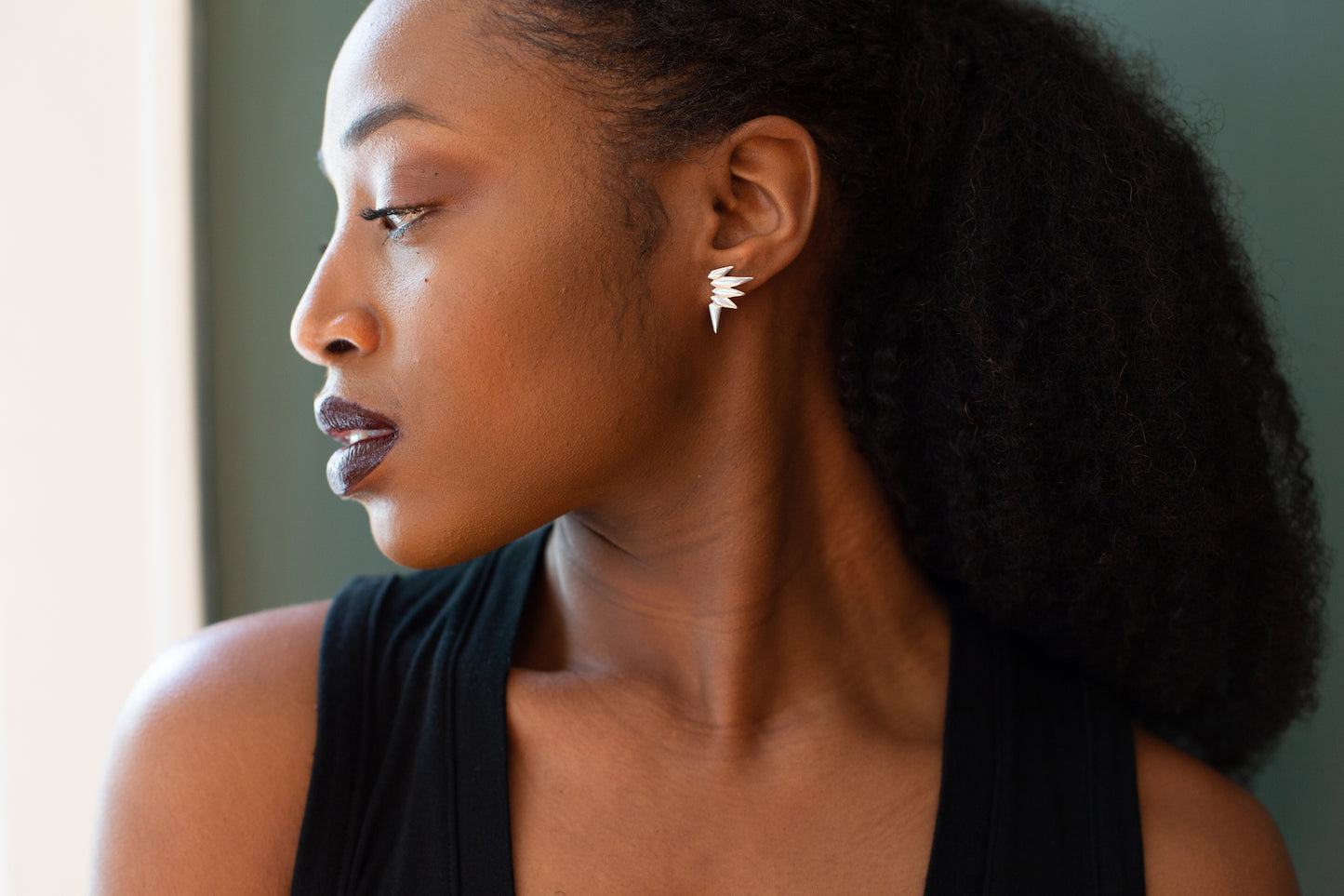 Woman wearing spiky stud earrings.
