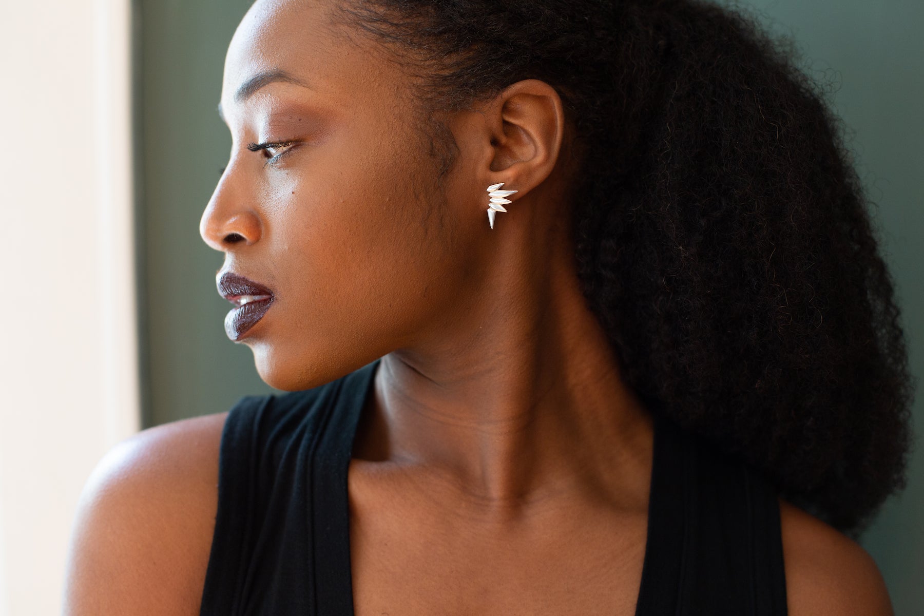 Woman wearing spiky stud earrings.