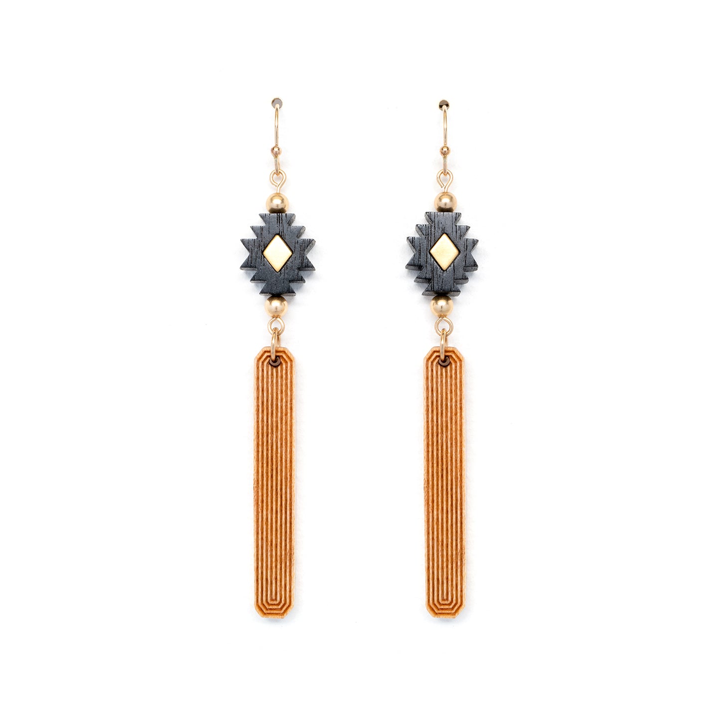 Black, gold and natural wood colored earrings made from laser carved wood laying flat on white backgound.