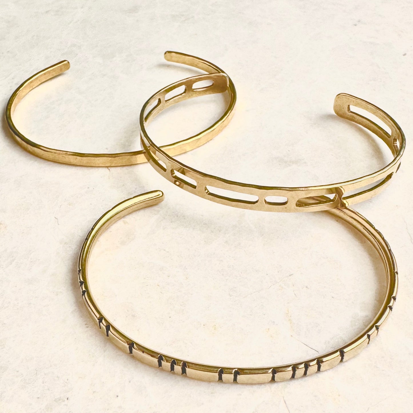 Handmade brass cuff bracelets in different styles.