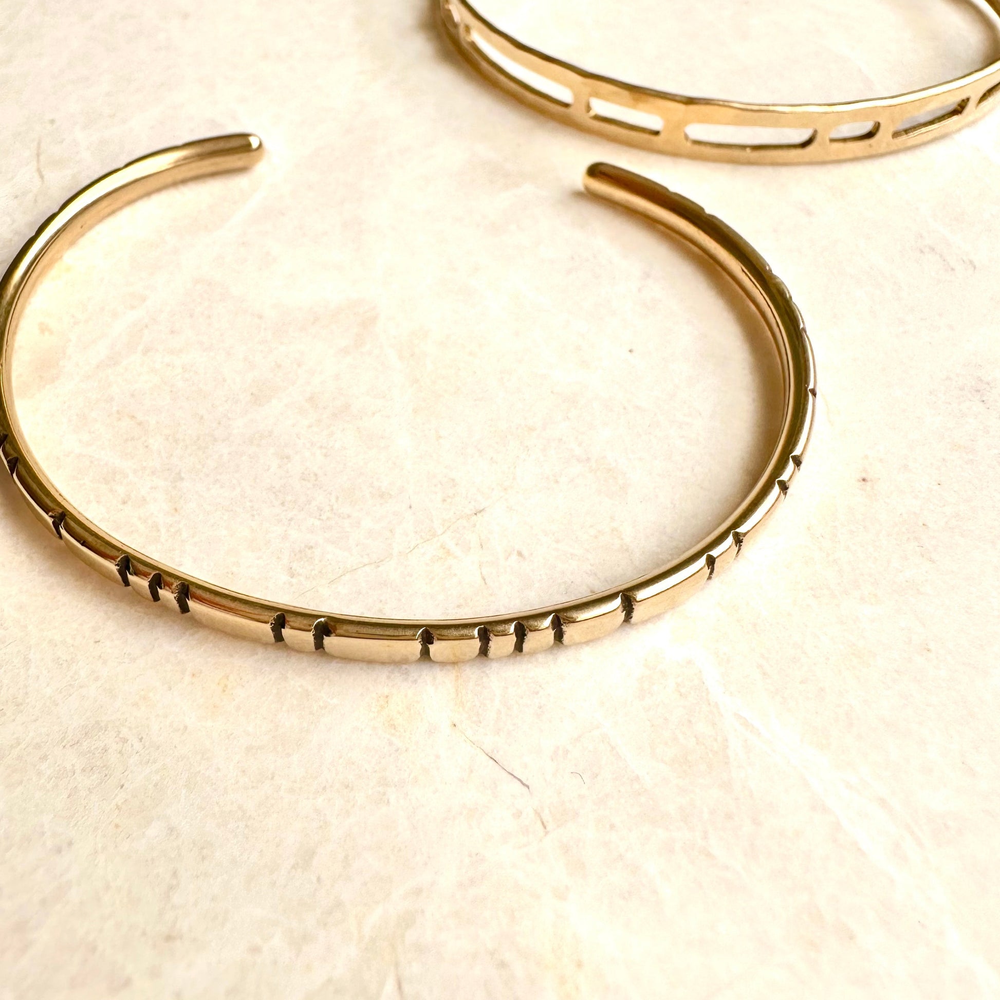Handmade brass cuff bracelet with line details.