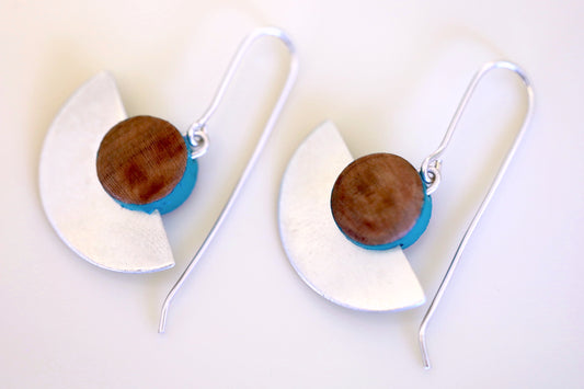 Wood and sterling silver earrings with turquoise painted accents close up.