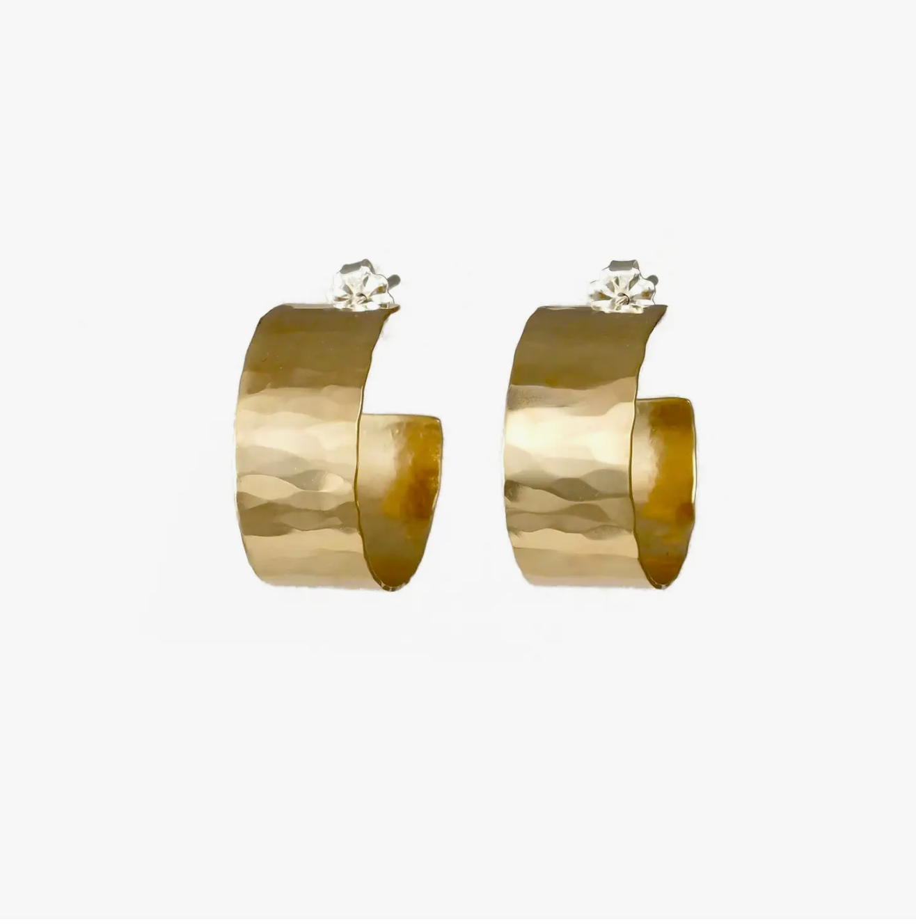 Small, flat hammered gold hoop earrings.