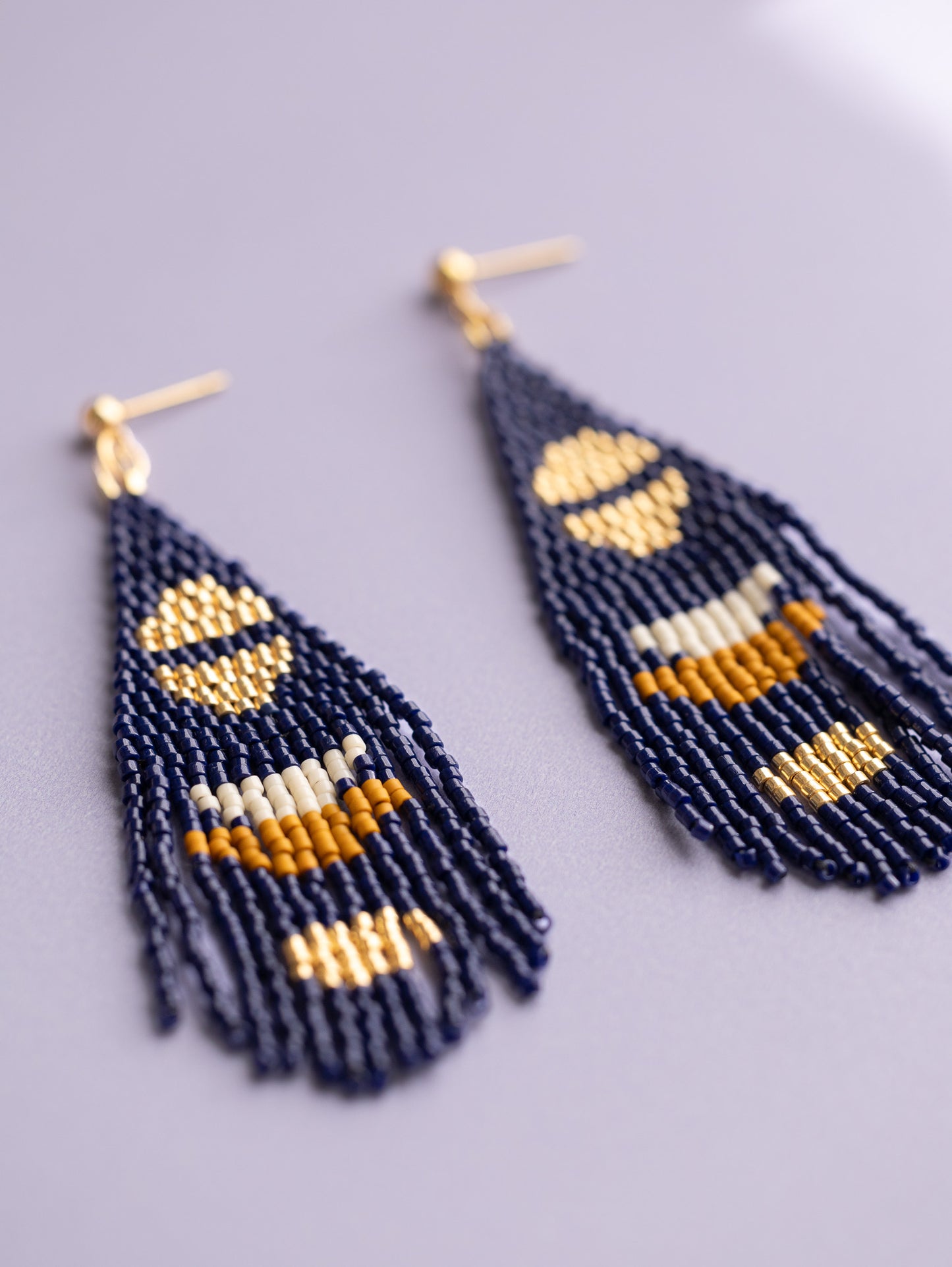 Navy hand beaded fringe earrings with gold half moon accents.