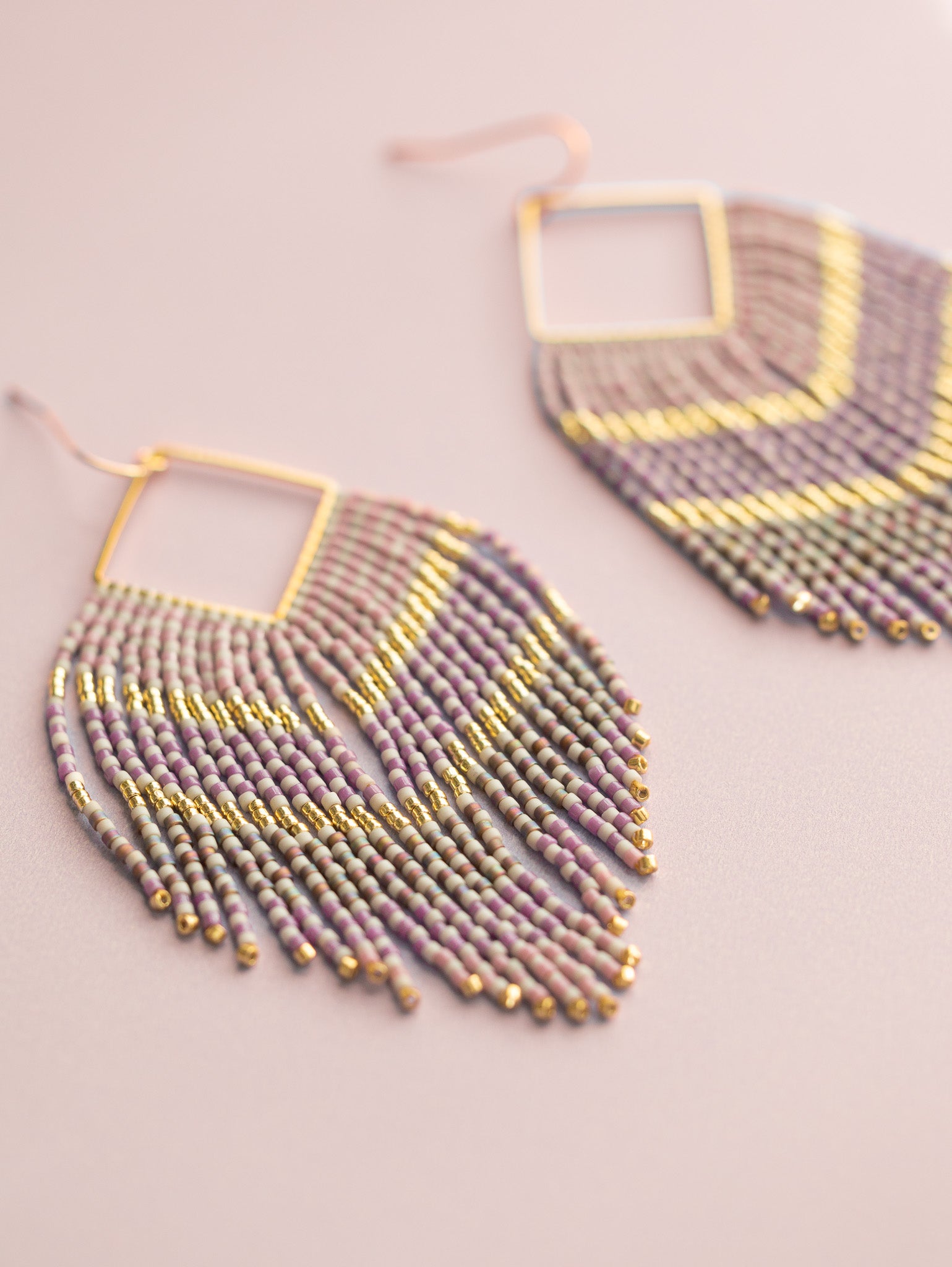 Purple, mauve and gold hand beaded fringe earrings with ombre pattern, close up.