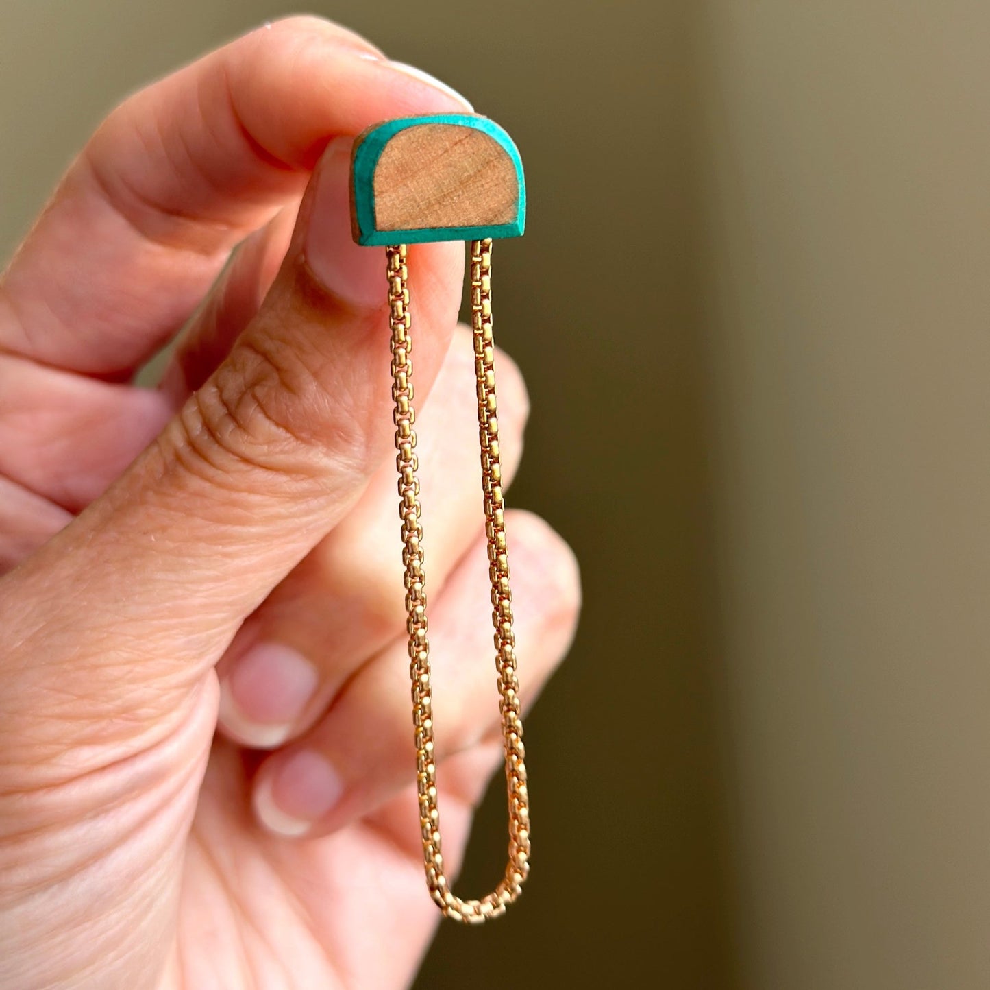 Stud earrings made from turquoise painted wood and brass chains.