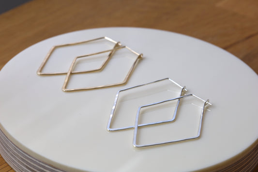 Diamond shaped hoop earrings in gold and silver.