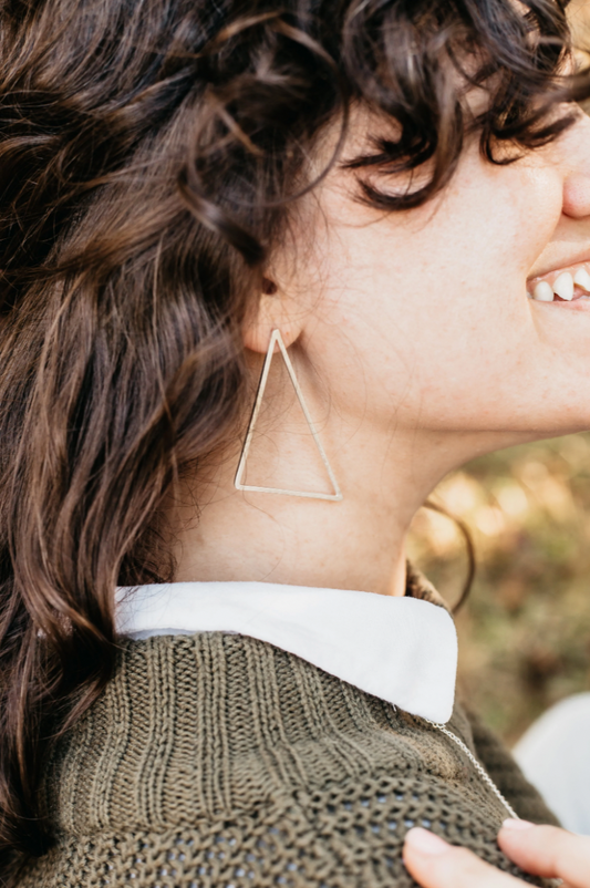 Woman wearing large triangle earring.
