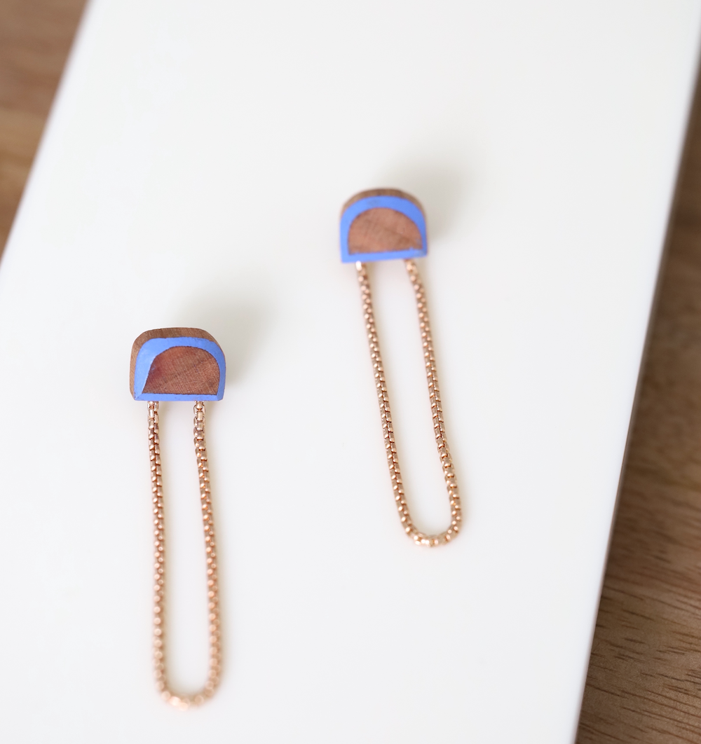 Stud earrings made from blue painted wood and brass chains.