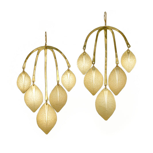 Large gold statement earrings made from leaf shapes.